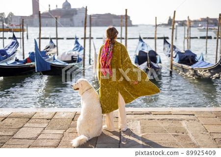 Stylish woman walking with dog in Venice, Italy Stylish woman walking with dog in Venice, Italy 89925409