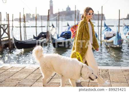 Stylish woman walking with dog in Venice, Italy 89925421