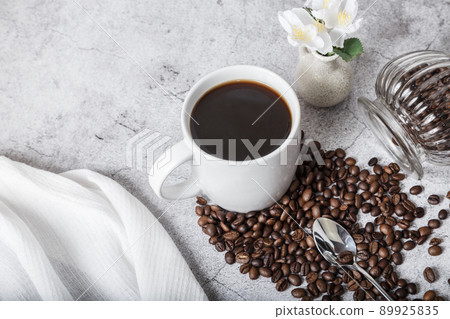 Coffee time. Morning drink in a white cup and bean of roasted coffee on the table. View from above Coffee time. Morning drink in a white cup and bean of roasted coffee on the table. View from above 89925835