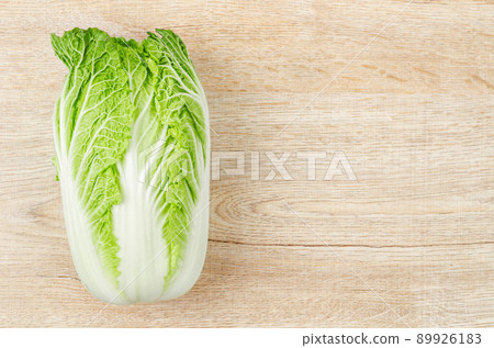 Fresh napa cabbage on white background on wooden background. Fresh napa cabbage on white background on wooden background. 89926183