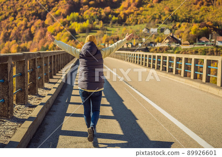 Montenegro. Woman touriste in background of Dzhurdzhevich Bridge Over The River Tara foggy morning. Travel around Montenegro concept. Sights of Montenegro 89926601