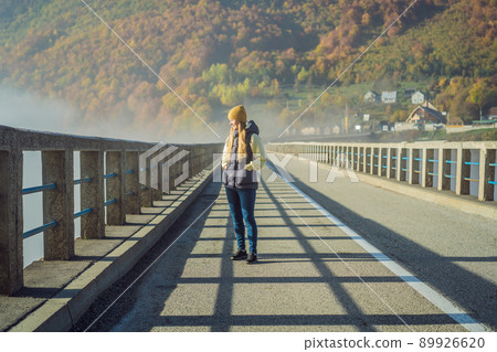 Montenegro. Woman touriste in background of Dzhurdzhevich Bridge Over The River Tara foggy morning. Travel around Montenegro concept. Sights of Montenegro 89926620