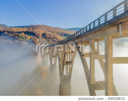 Montenegro. Dzhurdzhevich Bridge Over The River Tara foggy morning Montenegro. Dzhurdzhevich Bridge Over The River Tara foggy morning 89926652