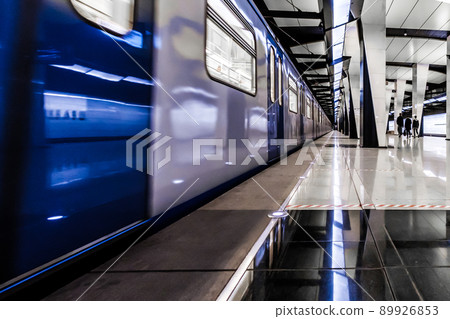 Modern metro station at night. A lonely girl is waiting for the train to arrive. 89926853