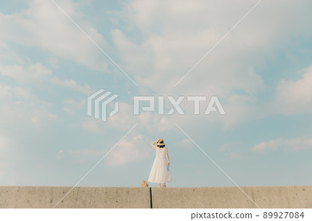 A woman in a dress and a beautiful summer sky A woman in a dress and a beautiful summer sky 89927084