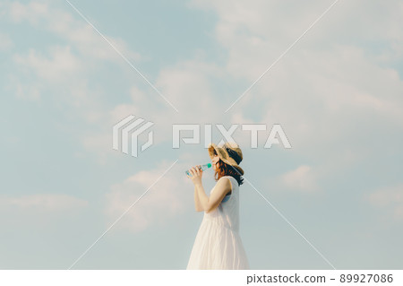 A woman in a dress and a beautiful summer sky 89927086