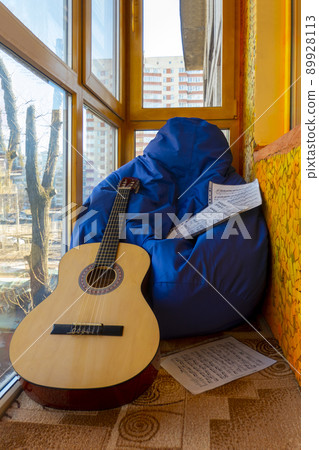 Composition with guitar and sheet music on balcony 89928113