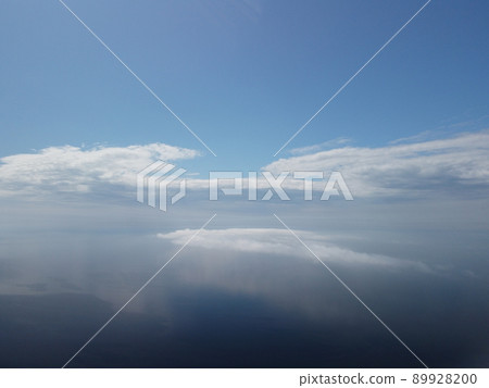 Aerial view. Blue sky sun and fog over calm sea. The drone flies over foggy and fluffy clouds. Abstract aerial nature summer ocean sunset sea and sky background. Vacation, travel and holiday concept. Aerial view. Blue sky sun and fog over calm sea. The drone flies over foggy and fluffy clouds. Abstract aerial nature summer ocean sunset sea and sky background. Vacation, travel and holiday concept. 89928200