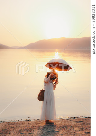 一個穿著裙子的相機女孩和美麗的夕陽天空 一個穿著裙子的相機女孩和美麗的夕陽天空 89928311