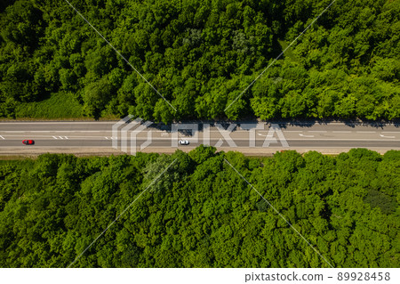 Road through the green forest, aerial view car drive going through forest, top down view forest, view from above, ecosystem and healthy environment concept and background. 89928458