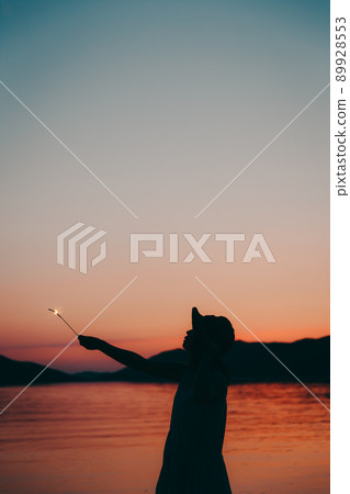 A silhouette of a woman in a dress and a beautiful sunset in a beautiful summer 89928553