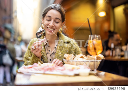 Woman with Italian snacks and drink at bar outdoors 89928696