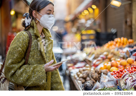 Woman buying food on the street market during pandemic Woman buying food on the street market during pandemic 89928864