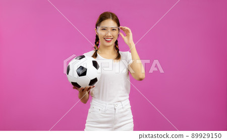 Portrait of Asian Young woman in white t-shirt over isolated pink background holding a soccer ball and looking at camera, football concept Portrait of Asian Young woman in white t-shirt over isolated pink background holding a soccer ball and looking at camera, football concept 89929150