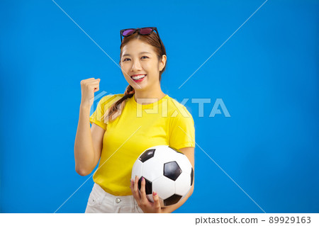 Asian Young Woman holding a soccer ball over isolated blue background, cheerful Positive emotion, sport concept Asian Young Woman holding a soccer ball over isolated blue background, cheerful Positive emotion, sport concept 89929163