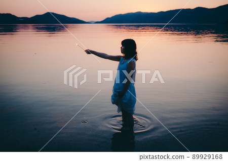 一個穿著裙子的女人的剪影和一個美麗的夏天的美麗日落 一個穿著裙子的女人的剪影和一個美麗的夏天的美麗日落 89929168