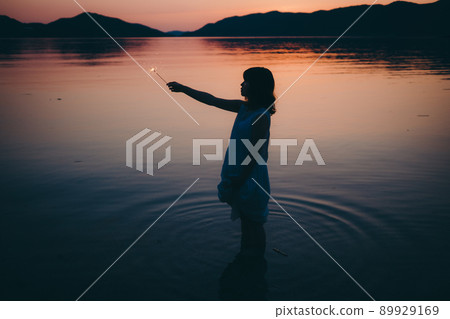 一個穿著裙子的女人的剪影和一個美麗的夏天的美麗日落 一個穿著裙子的女人的剪影和一個美麗的夏天的美麗日落 89929169