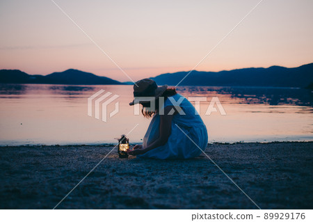 一個穿著裙子的女人的剪影和一個美麗的夏天的美麗日落 一個穿著裙子的女人的剪影和一個美麗的夏天的美麗日落 89929176