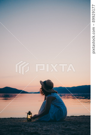 一個穿著裙子的女人的剪影和一個美麗的夏天的美麗日落 一個穿著裙子的女人的剪影和一個美麗的夏天的美麗日落 89929177