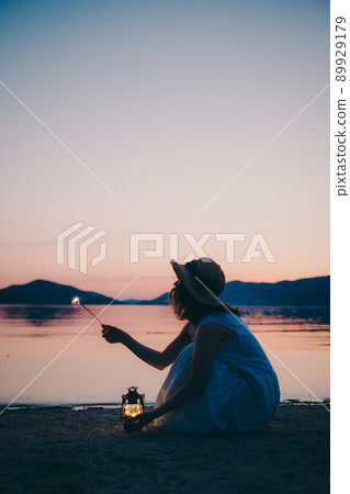 一個穿著裙子的女人的剪影和一個美麗的夏天的美麗日落 一個穿著裙子的女人的剪影和一個美麗的夏天的美麗日落 89929179
