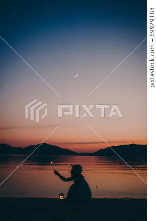 A silhouette of a woman in a dress and a beautiful sunset in a beautiful summer 89929183