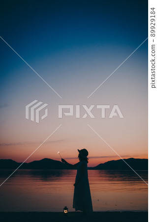 一個穿著裙子的女人的剪影和一個美麗的夏天的美麗日落 一個穿著裙子的女人的剪影和一個美麗的夏天的美麗日落 89929184