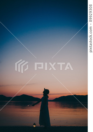 一個穿著裙子的女人的剪影和一個美麗的夏天的美麗日落 一個穿著裙子的女人的剪影和一個美麗的夏天的美麗日落 89929308