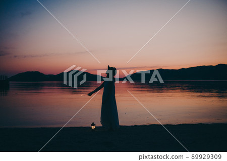 A silhouette of a woman in a dress and a beautiful sunset in a beautiful summer A silhouette of a woman in a dress and a beautiful sunset in a beautiful summer 89929309