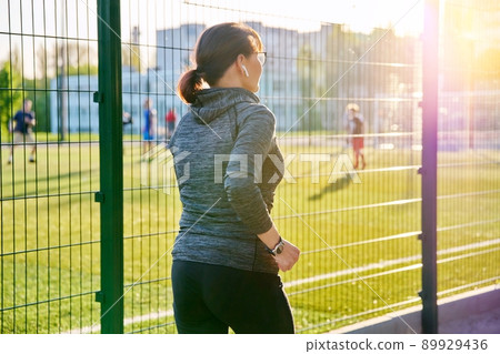 Mature active woman running outdoor, near stadium Mature active woman running outdoor, near stadium 89929436
