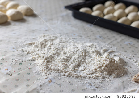 Flour and dough for pies on the kitchen table. Baking at home. Selective focus. Flour and dough for pies on the kitchen table. Baking at home. Selective focus. 89929585