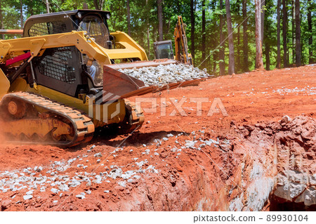 Industrial construction residential areas a small tractor of gravel moving Industrial construction residential areas a small tractor of gravel moving 89930104