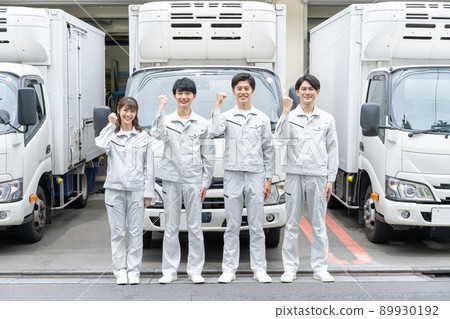 Portrait of young men and women in guts pose wearing work clothes standing in front of the truck Portrait of young men and women in guts pose wearing work clothes standing in front of the truck 89930192