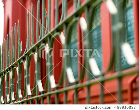 Wrought iron fence beside a street in the city Wrought iron fence beside a street in the city 89930858