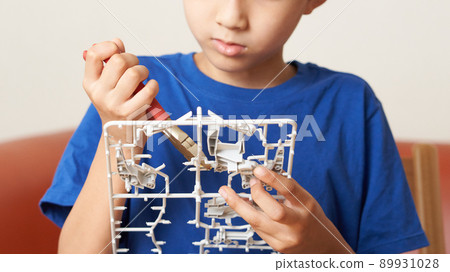 Elementary school boy assembling a plastic model 89931028