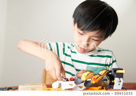 Elementary school boy assembling a robot 89931035