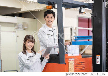 一名男子在配送中心駕駛叉車，一名年輕女工下達指令 89931107