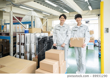 Two young men carrying luggage at a distribution center Two young men carrying luggage at a distribution center 89931290