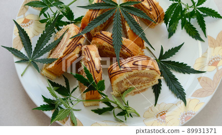 Sweet roll with marijuana oil on white plate. Cannabis kitchen Sweet roll with marijuana oil on white plate. Cannabis kitchen 89931371
