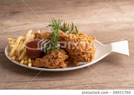 Fried chicken and potato chip with rosemary leaf, Junk food high calorie served on white plate Fried chicken and potato chip with rosemary leaf, Junk food high calorie served on white plate 89931760