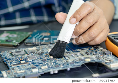 Technician use brush and air blower ball to clean dust in circuit board computer. Repair upgrade and maintenance technology. Technician use brush and air blower ball to clean dust in circuit board computer. Repair upgrade and maintenance technology. 89931762