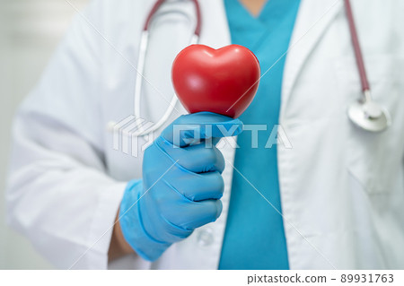 Doctor holding a red heart in hospital ward, healthy strong medical concept. Doctor holding a red heart in hospital ward, healthy strong medical concept. 89931763