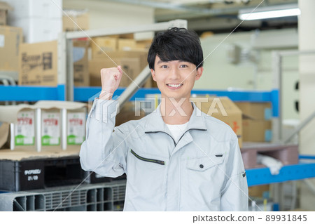 Face up of a young smiling man doing a guts pose in a distribution center 89931845