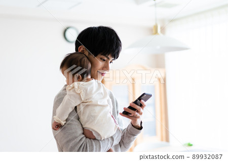 A man who looks up childcare on his smartphone A man who looks up childcare on his smartphone 89932087