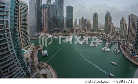 Dubai marina tallest skyscrapers and yachts in harbor aerial day to night timelapse. 89932715