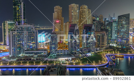 Dubai Marina with several boats parked near waterfront and skyscrapers around canal aerial night timelapse. Dubai Marina with several boats parked near waterfront and skyscrapers around canal aerial night timelapse. 89932861