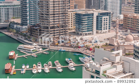 Many yachts and boats are parked in harbor aerial timelapse in Dubai Marina 89932892