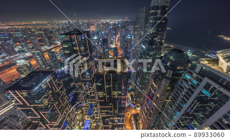 Skyline panoramic view of Dubai Marina showing canal surrounded by skyscrapers along shoreline night timelapse. DUBAI, UAE 89933060
