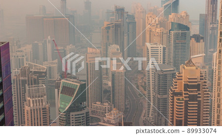 Skyline panoramic view of Dubai Marina showing an artificial canal surrounded by skyscrapers along shoreline timelapse. DUBAI, UAE 89933074