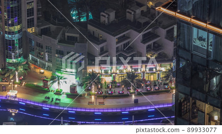 Aerial view on Dubai Marina illuminated promenade with palms ad yachts night timelapse. Aerial view on Dubai Marina illuminated promenade with palms ad yachts night timelapse. 89933077
