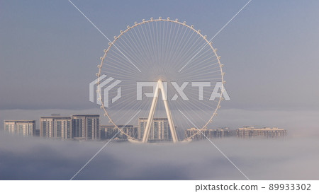 Bluewaters island with modern architecture and ferris wheel covered by morning fog aerial timelapse. 89933302